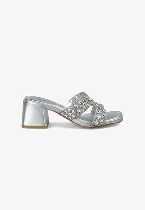 Silberne Blockabsatzsandalen mit breiten Riemen, die mit klaren Rhinestones verziert sind, aus glattem, glänzendem Material und mit offenem Zehendesign.