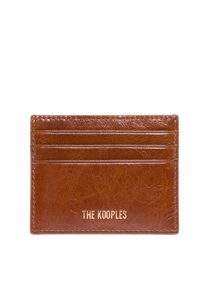 Portacarte in pelle marrone con tre fessure per carte e logo "THE KOOPLES" impresso in oro al centro anteriore.