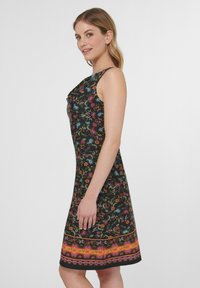 Ärmelloses schwarzes Kleid mit bunten Blumenmustern und einem lebendigen, mehrfarbigen Saum. Glatter Stoff und figurbetontes Design.