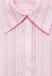 Camicia rosa chiaro con righe bianche larghe, dotata di colletto classico e una fila centrale di bottoni. Tessuto di trama liscia.