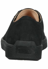 Black suede slip-on shoes with a rounded toe, textured rubber sole, and minimal detailing on the heel. Interior features a tan lining.