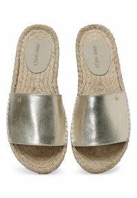Par af flade slidesandaler med metalisk guldremme og vævede jute-såler, der har en polstret indersål med mærket "Nine West."