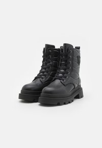 Zwarte veterschoenen in een militair style, gemaakt van soepel leer, met een gevoerd ontwerp, stevige rubberen zool en logo detail aan de zijkant.