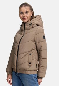 Beige gewatteerde jas met een capuchon, voorzien van een ritssluiting, diagonale stiknaden, zijzakken en een ronde logo patch op de linkerarm.
