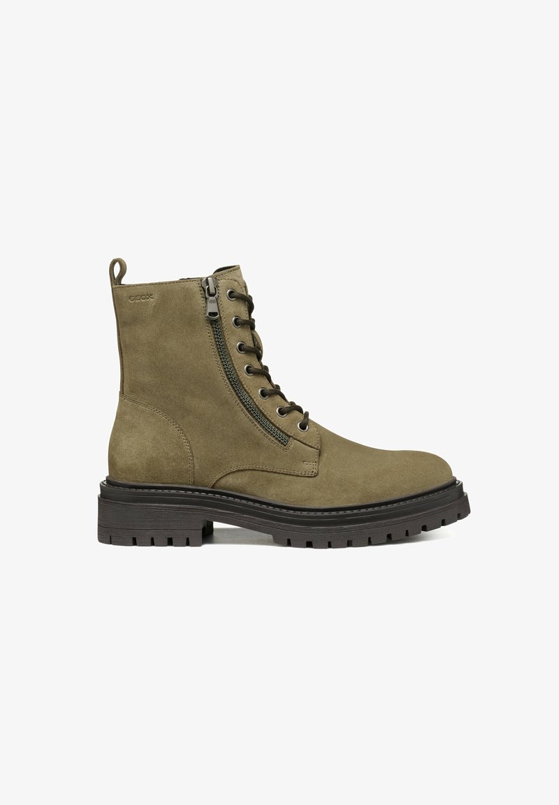 Bota de ante verde oliva con cordones en la parte frontal, cremallera lateral y suela de goma texturizada. Presenta una puntera reforzada y un diseño de altura hasta el tobillo.