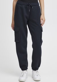 Navyblauwe joggers gemaakt van zachte stof. Voorzien van een verstelbare tailleband, elastische boorden en zijvakjes.