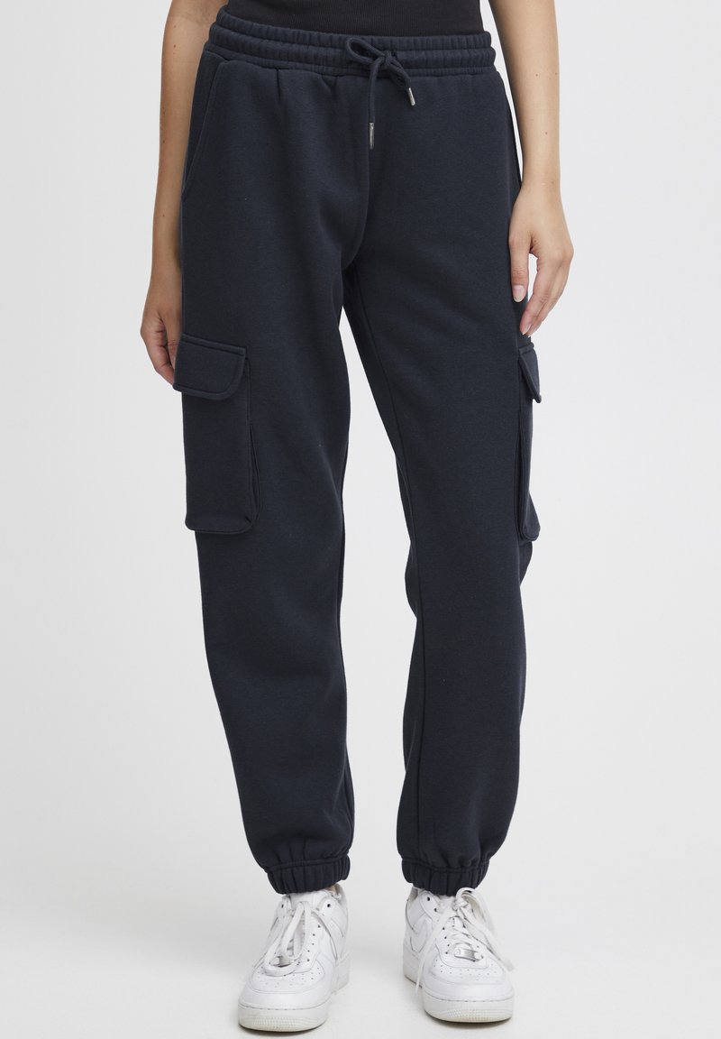Navyblauwe joggers gemaakt van zachte stof. Voorzien van een verstelbare tailleband, elastische boorden en zijvakjes.