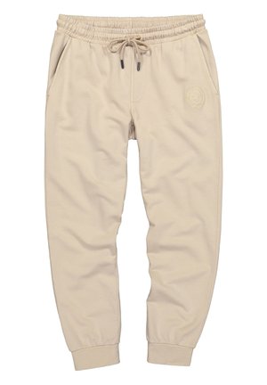 Beige joggerbukser med snor i taljen, elastisk talje og manchetter, sidelommer og et diskret rundt broderet logo på højre lår.
