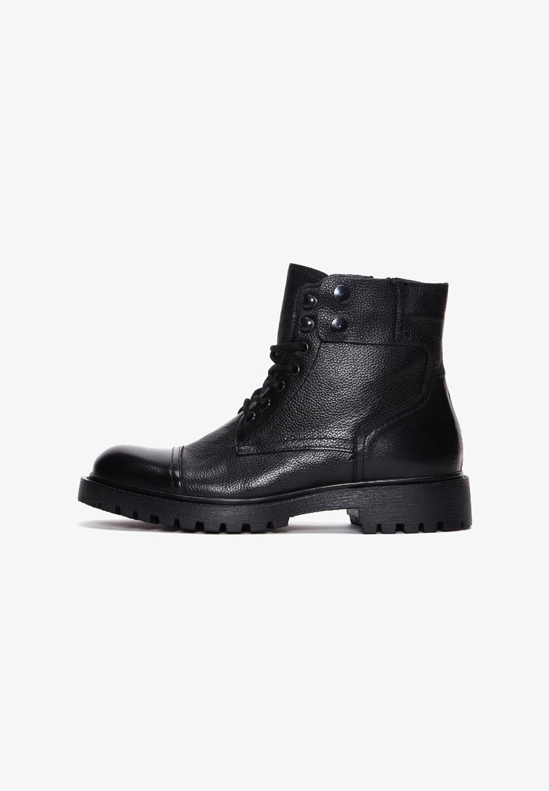 Schwarze Leder-Stiefeletten mit strukturiertem Finish, runder Zehenform, Schnürdesign und zwei Druckknöpfen an der Oberseite. Dicke gummierte Sohle mit Profil.