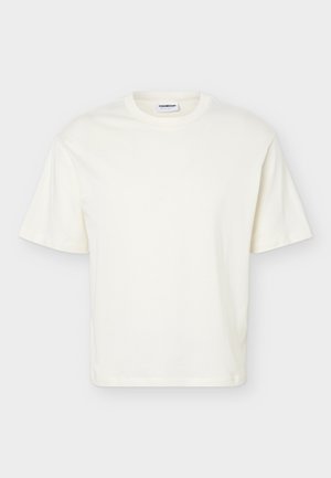 Prosty biały T-shirt z krótkim rękawem i okrągłym dekoltem o luźnym kroju, przedstawiony na jasnoszarym tle.