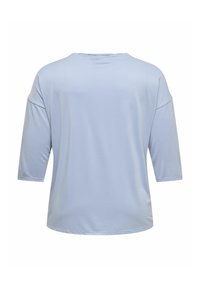 Lyseblå, myk tekstiltop med rund hals og trekvartlange ermer. Har en avslappet passform og glatt tekstur. Ingen merkbare mønstre.