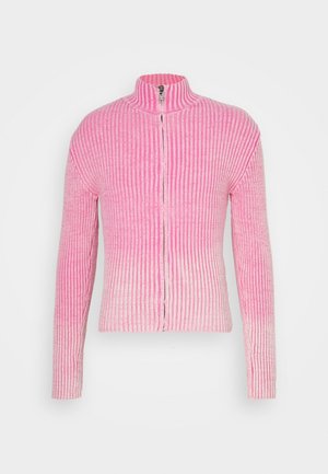Pull zippé en maille côtelée rose avec manches longues et col haut sur fond blanc.