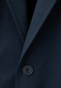 Revers et col de veste de costume bleu foncé avec un seul bouton noir fermé au centre devant.