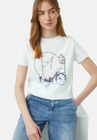 T-shirt en coton blanc avec un design graphique d'une bicyclette aux accents pastel et le texte "CASUAL IDENTITY EST 2010" au centre.