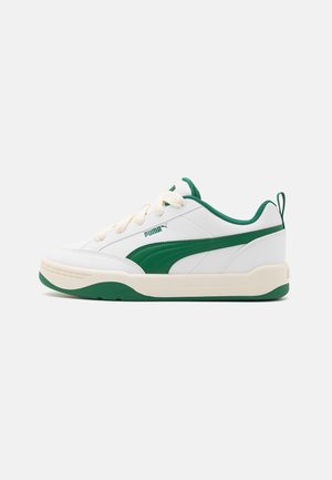 Zapatilla blanca con acentos verdes y paneles texturizados. Presenta cordones redondos, suela acolchada y perfil delgado. Talón reforzado con una cinta de agarre.