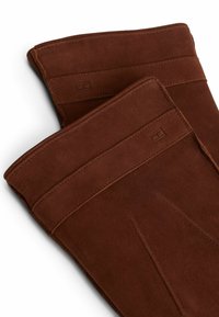 Brown suede gloves with a smooth texture, featuring a simple design and stitched detailing along the seams and openings.