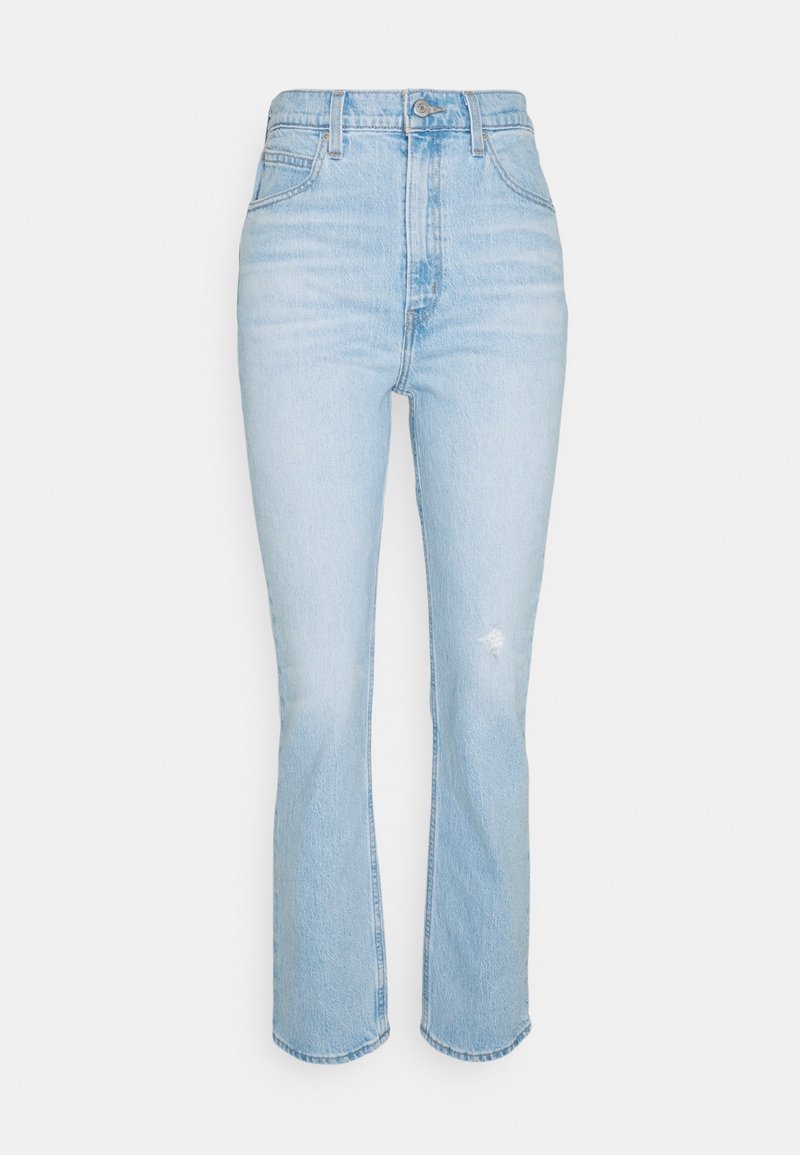 Jeans bleu clair taille haute avec fermeture à bouton et fermeture éclair, poches avant, passants de ceinture, et légère décoloration ainsi que des effets usés sur la cuisse droite.