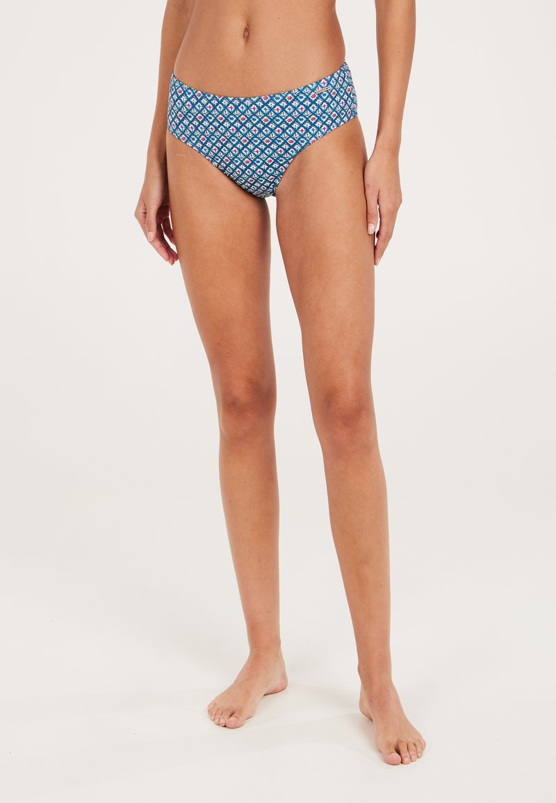 Bikini donji dio u plavoj boji, s geometrijskim uzorkom i crvenim i bijelim akcentima. Srednje visoki kroj, glatka tkanina i elastična pojas.