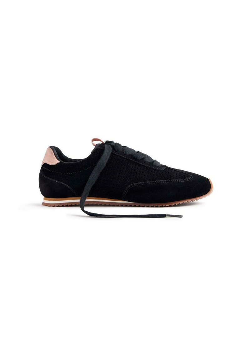 Botte de sport noire en daim, présentant une tige texturée, un bout rond et une semelle en caoutchouc clair. Un lacet est défait.