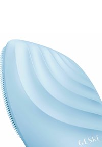 Brosse à cheveux bleue avec un design ondulé, des poils texturés et une finition lisse. Porte le nom de la marque "GESKE" en lettres blanches.