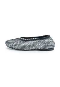 Scarpa flat con un design in mesh nero e argento, caratterizzata da una tomaia testurizzata, punta rotonda e tacco basso. Fodera morbida e accenti minimalisti.