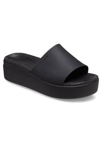 Sandalia de plataforma negra sin hebillas con una banda ancha, fabricada en material suave; planta texturizada y diseño elegante y minimalista.