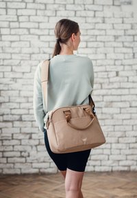 Beige Laptop-Tasche mit zwei oberen Griffen und verstellbarem Schultergurt, aus weichem Material, mit Reißverschlüssen und einem Logodetail.