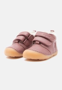 Rosa Leder-Kinderschuhe mit zwei Klettverschlüssen und einer strukturierten beigen Gummisohle, die ein weiches Futter für zusätzlichen Komfort bietet.