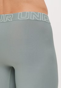 Lys grønne tettsittende leggings med en teksturert overflate og en bred elastisk midje med teksten "YOUR UNDER" i fet skrift.