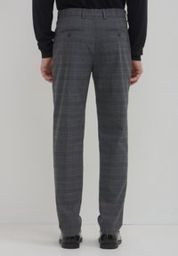 Helle karierte Hose mit taillierter Passform, ausgestattet mit einer glatten Textur, zwei Gesäßtaschen und einem klassischen Karo-Muster.