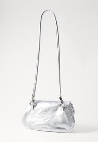 Borsa metallica argentata con una texture liscia, una forma curvata e una lunga tracolla. Presenta dettagli lucenti e un logo discreto sulla parte anteriore.