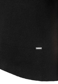 Pull noir, tissu doux, ourlet et texture des poignets côtelés. Présente une petite étiquette blanche portant la mention "MORE & MORE" près du bas.