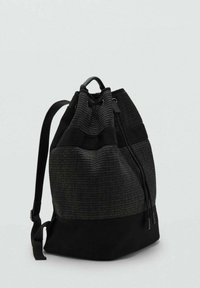 Mochila negra de cuerdas con superficie texturizada, que presenta una base negra sólida y correas para los hombros ajustables.