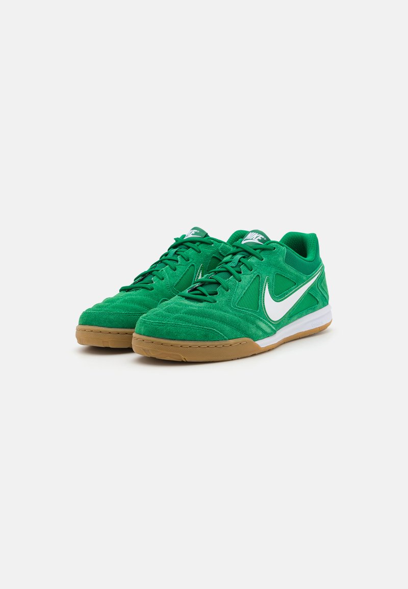 Zapatillas deportivas de ante verde con el logo de Nike en blanco, cordones planos y suela de goma. Presentan una lengüeta acolchada y un panel lateral texturizado.