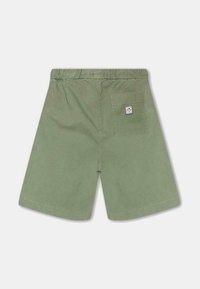 Pantalones cortos de algodón verdes con una cintura elástica, que cuentan con un bolsillo trasero y una pequeña etiqueta de la marca en el bolsillo.