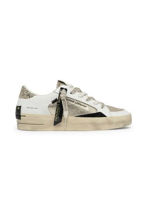 Sneaker bianca e oro a basso profilo con accenti scintillanti, suola beige spessa, etichetta logo nera e logo "Crime London" sul lato e sui lacci.