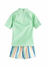 Mintgrøn rashguard med korte ærmer, der har en lynlås på ryggen. Kombineret med stribede badetights i blå, orange og hvid.