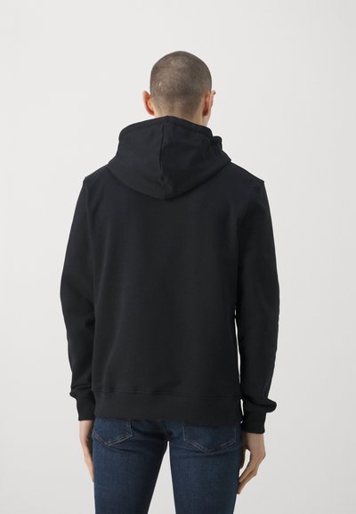 Črna kapuca s kapuco iz mehkega blaga, opremljena s kengurujskim žepom in rebrastimi manšeti, s sproščenim krojem in minimalnimi detajli.