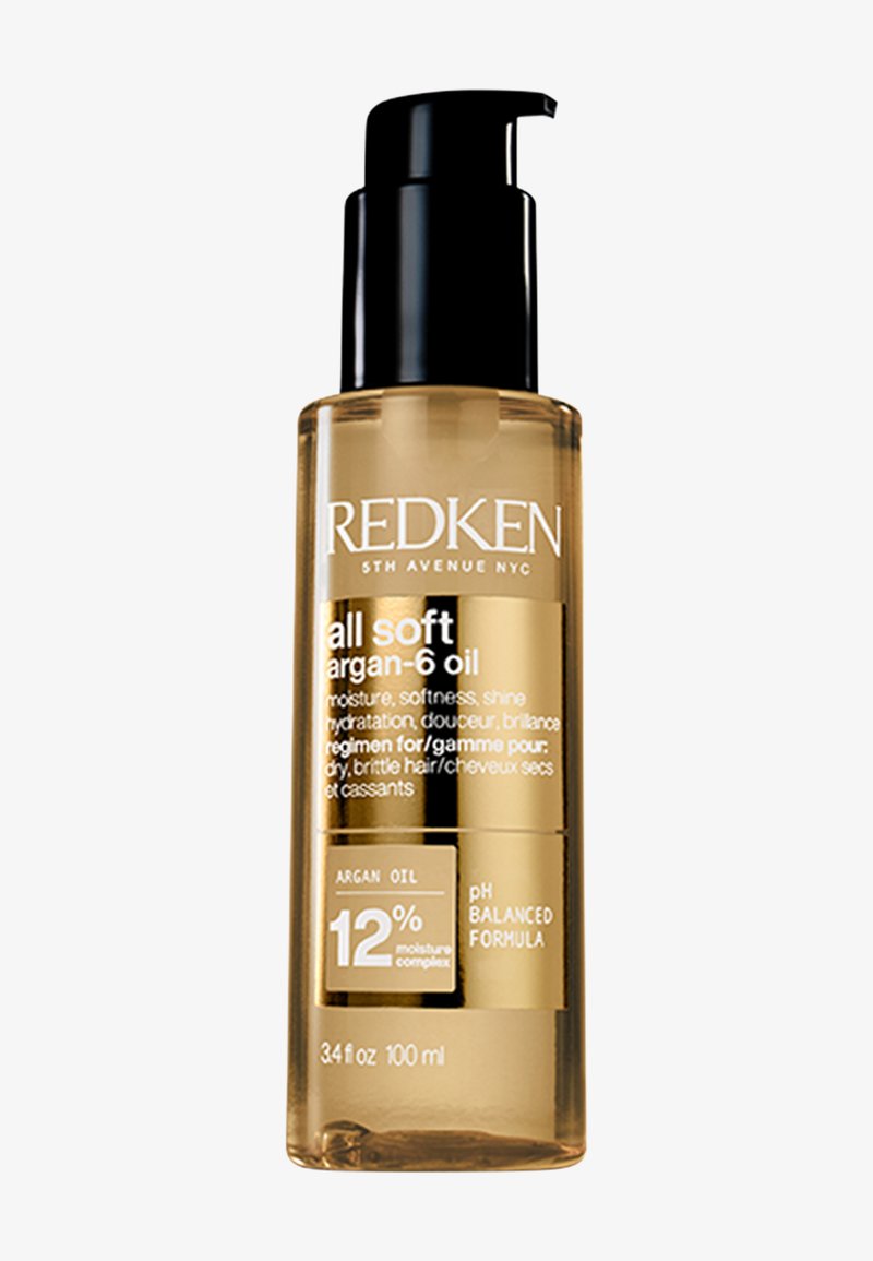 Redken All Soft Argon-6 olie in een doorzichtige cilindrische fles, gouden vloeistof, zwarte pomp, met witte tekst die de productvoordelen beschrijft.
