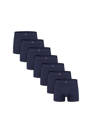 Zeven paar donkerblauwe herenenboxers gerangschikt in een diagonale lijn op een witte achtergrond.
