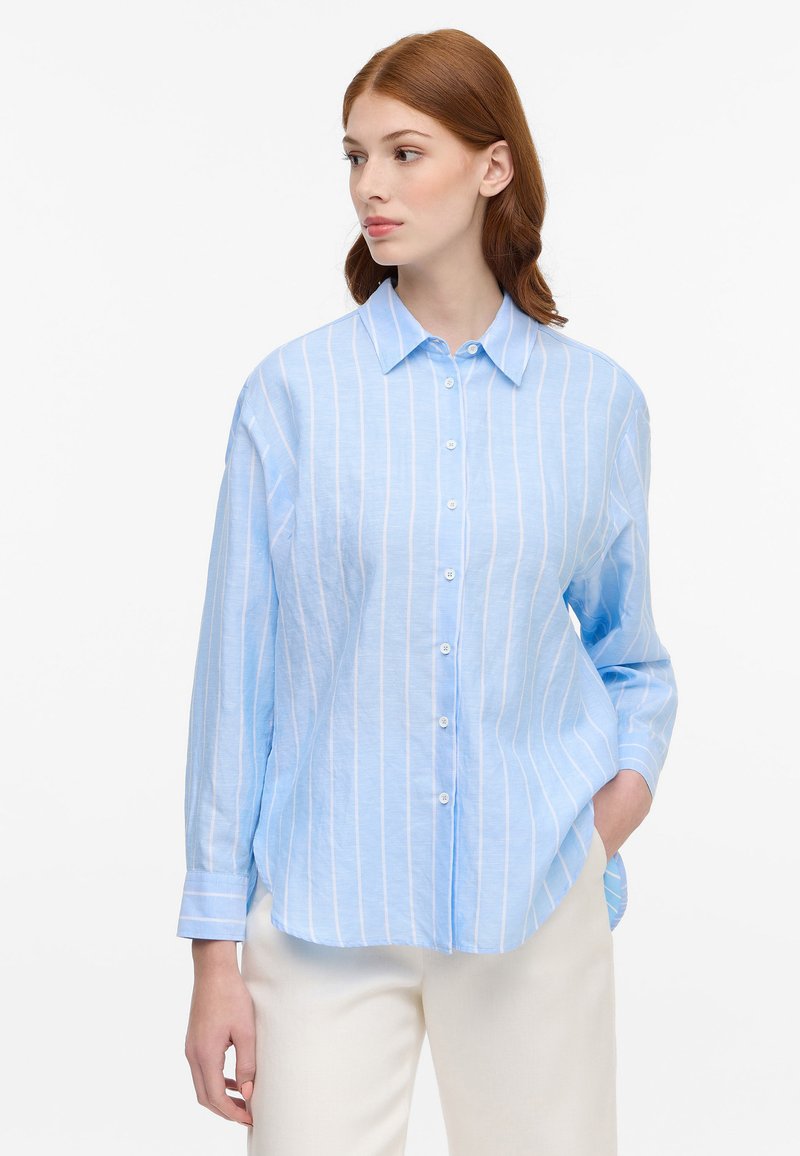 Light blue button-up shirt with white vertical stripes, long sleeves, and a spread collar, crafted from a lightweight fabric.