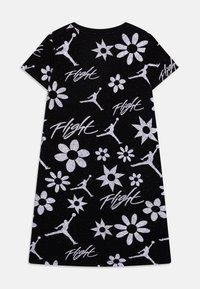 Czarna sukienka t-shirt z całkowitym białym nadrukiem przedstawiającym kwiaty i sylwetki koszykówki, z wyrazem "Flight" w pogrubionej czcionce.