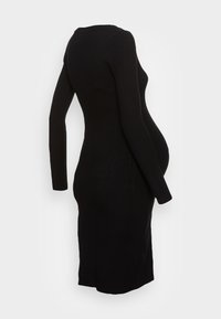 Abito nero a costine con maniche lunghe, silhouette aderente e scollatura rotonda, progettato per comfort e elasticità.