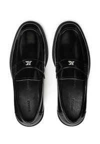 Black patent leather loafers with a rounded toe, decorative stitching, silver logo accent, and textured rubber sole.