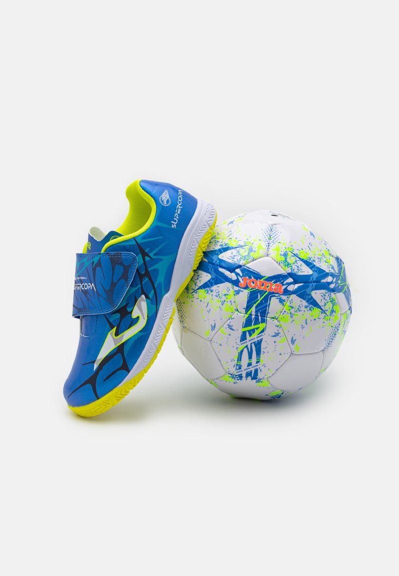Ghete de fotbal albastre cu un sistem de prindere cu arici, talpă din cauciuc texturat și accente de culoare galben neon, alături de o minge albă cu un design cu stropi de culoare albastră și verde.