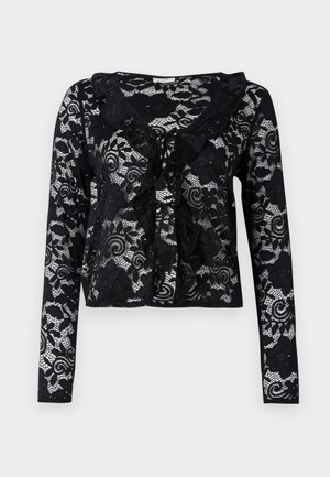 Cardigan de encaje negro con mangas largas, patrones florales, cuello con volantes, diseño de frente abierto y detalle de lazo en el escote.