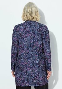 Camicia a maniche lunghe realizzata in tessuto leggero, caratterizzata da uno sfondo blu navy scuro con un motivo paisley in rosa, viola e bianco.