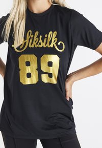 Černý sportovní dres z jemné síťoviny se zlatým logem "Siksilk" a číslem "89" v tučném, lesklém písmu. Krátké rukávy a volný střih.