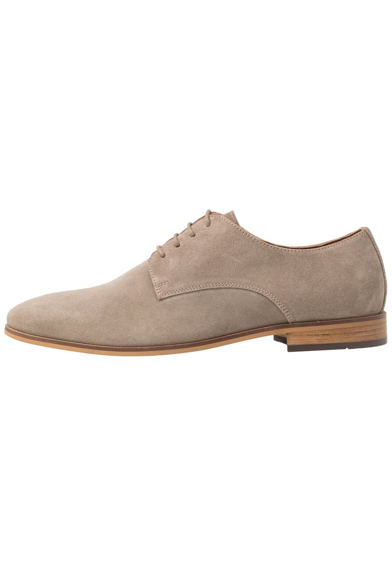 Zapato oxford de ante beige con textura suave, punta redondeada y cierre de encaje de cinco ojales. Tacón de piel marrón claro apilado.