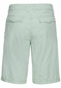 Shorts vert menthe clair en tissu texturé, avec deux poches plaquées à l'arrière et des accents de couture le long de la taille et de l'ourlet.